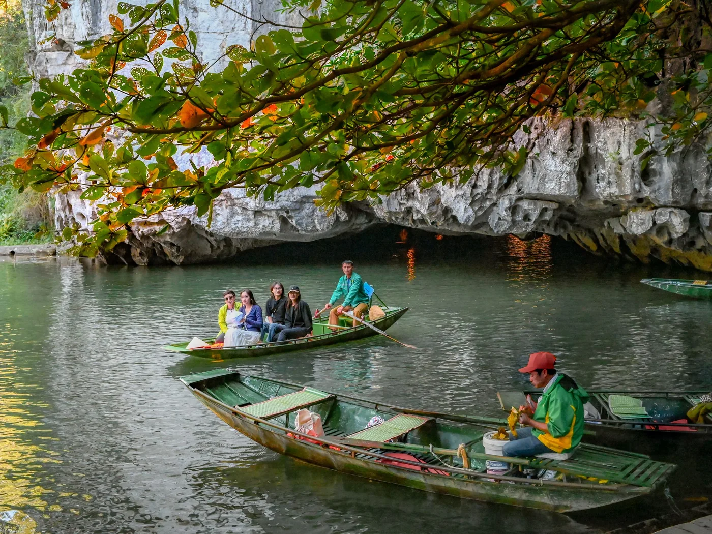 Una barca di legno entra nella caverna fluviale di Phong Nha Cave